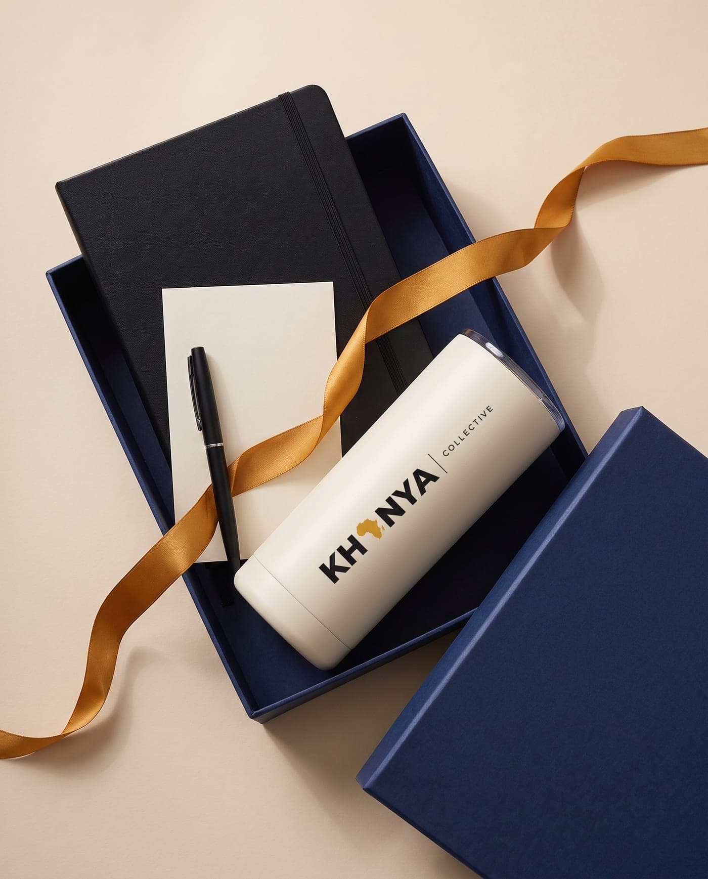 Navy corporate gift box with a notebook, pen, card and Khanya Collective branded tumbler